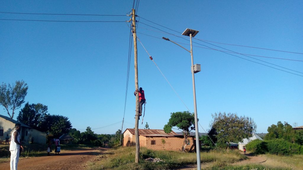 Rex engineer inspecting streetlight installed in Biharamulo
