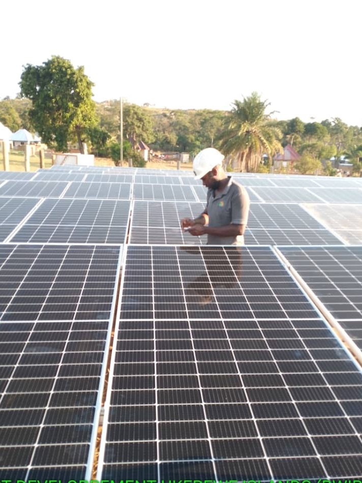 Rex Energy engineer inspecting mini-grid installed on Bwiro island Ukerewe